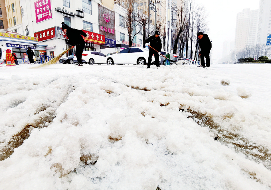 物业人员铲冰除雪，方便过往市民出行。